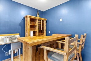 A room with a wooden table and chairs, a cabinet with glass doors, and a blue wall. - Lake Views Hot Tub Fire Pit Micro Events (Morganton)