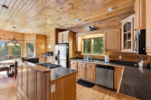 Una cocina moderna con armarios de madera, electrodomésticos de acero inoxidable y una isla grande.