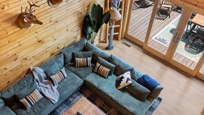 Una sala de estar moderna con un sofá modular, cojines decorativos, una mesa de centro y una lámpara.