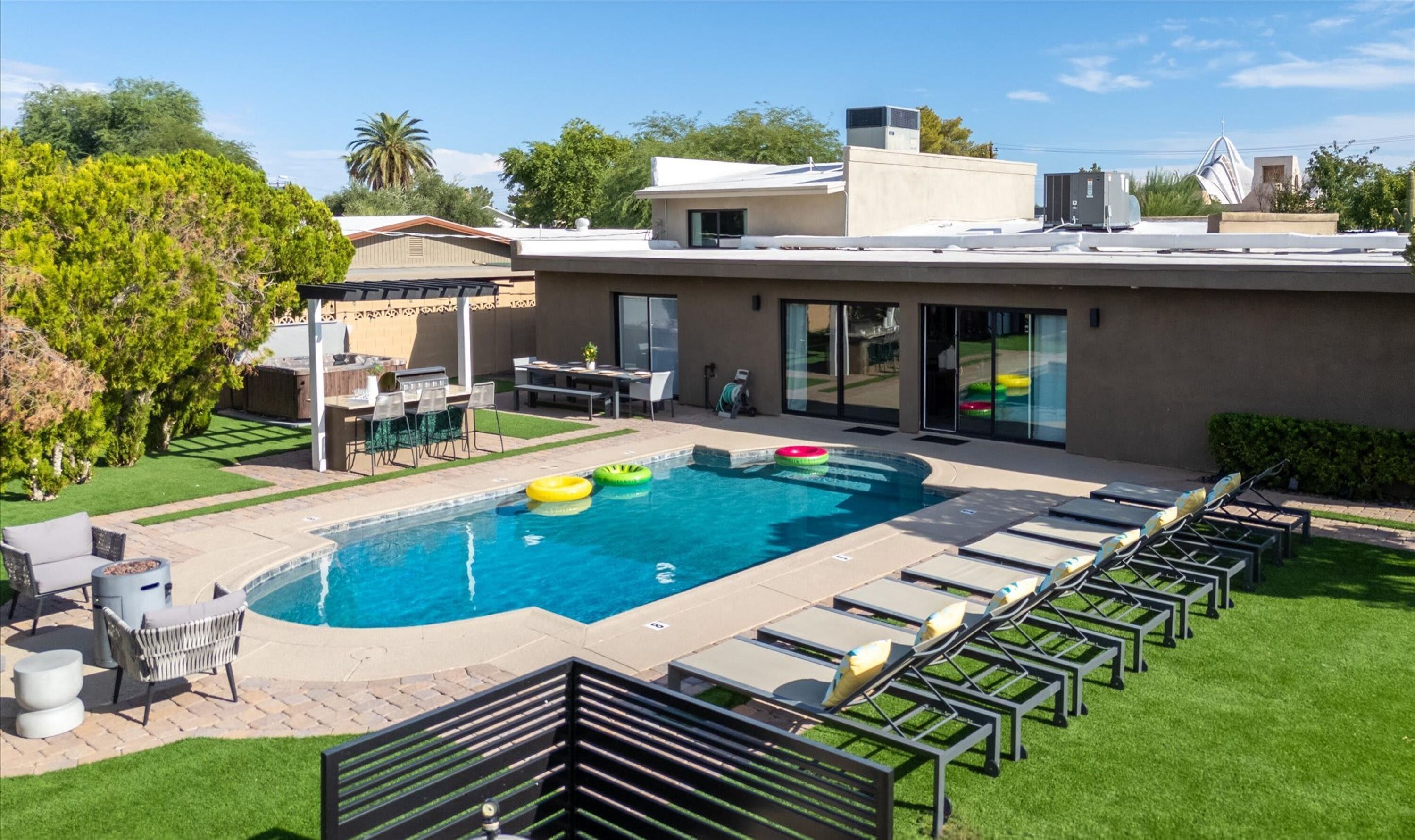 A swimming pool with lounge chairs and a barbecue area.