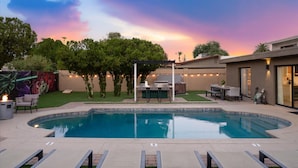 A swimming pool with lounge chairs and a barbecue area. - Casa Citrus 6BR Heated Pool Spa Modern Design (Scottsdale)