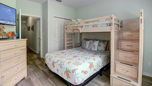 A child's bedroom with bunk beds, a dresser, and a television. - Piggy s Perch- 2 Balconies Direct Pool Access (Port Aransas)
