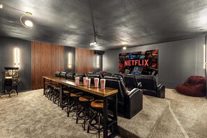 Ein Konferenzraum mit langem Tisch, mehreren Stühlen, Popcorn und einem großen Netflix-Poster an der Wand.