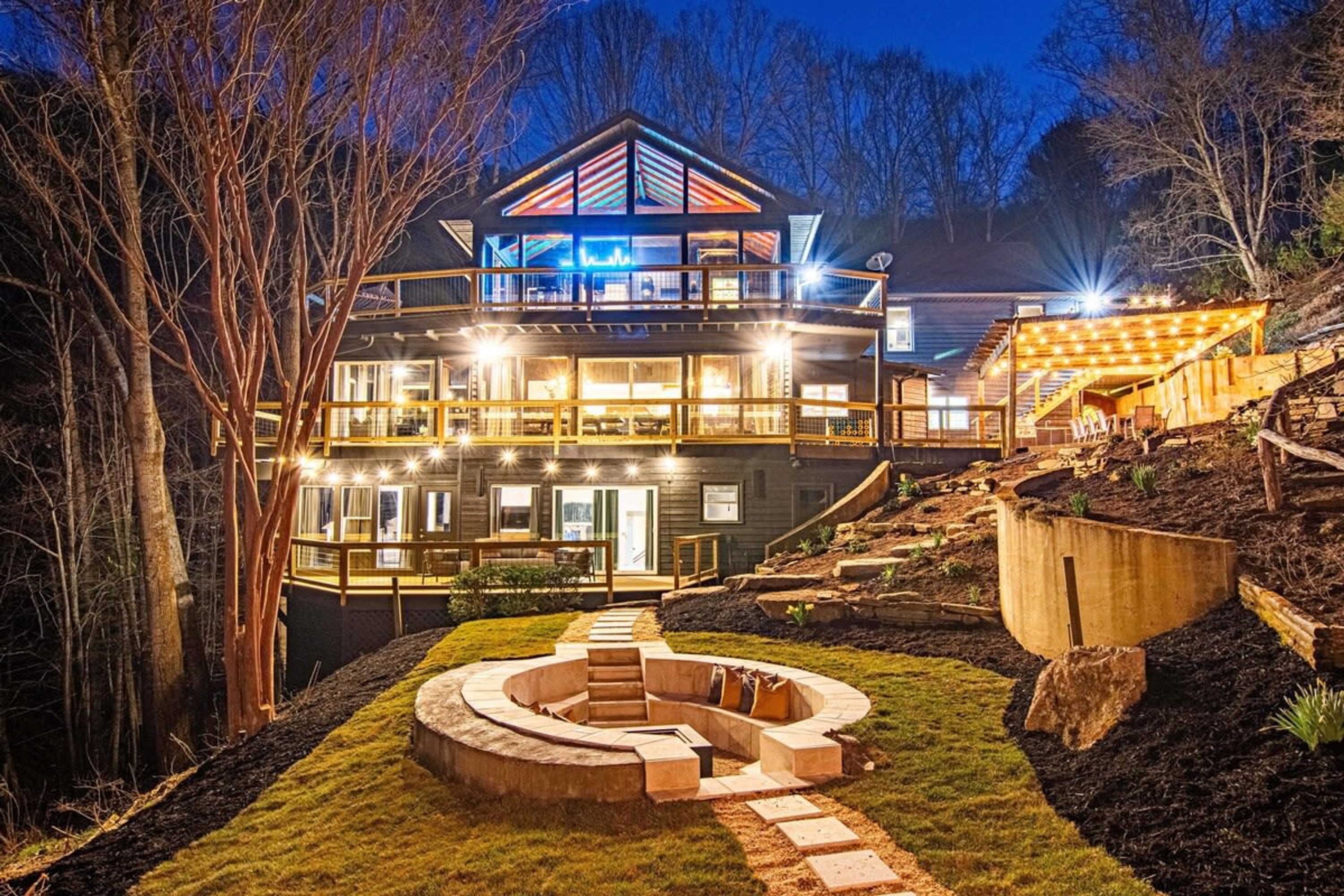 Ein mehrstöckiges Haus mit einer großen Terrasse und einer runden Sitzgruppe im Freien.