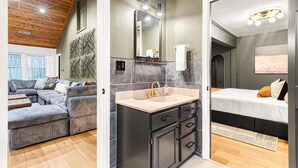 A modern interior with a sofa, a bathroom with a sink, and a bed. - 7k sq ft Mountain Estate -the Most Epic Experience (Asheville)