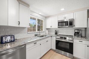 A modern kitchen with white cabinets, a built-in microwave, a toaster, and an oven. - 3 Miles to Honeymoon Island Firepit Pool (Palm Harbor)