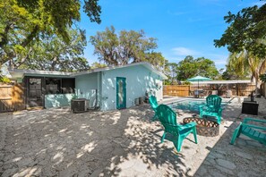 A backyard with a swimming pool, outdoor furniture, and a small building. - 3 Miles to Honeymoon Island Firepit Pool (Palm Harbor)