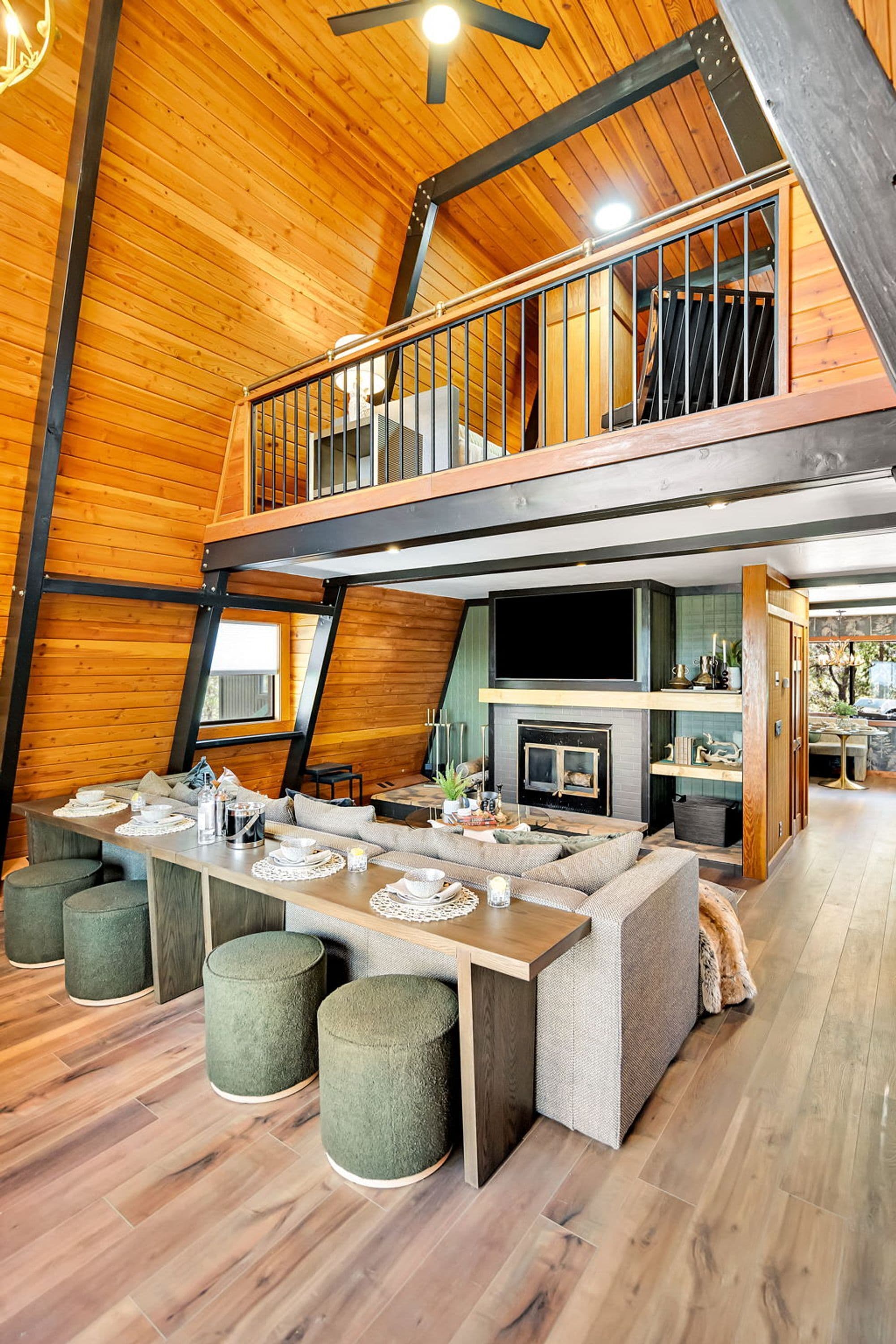 A spacious loft-style room with a high ceiling, a mezzanine level, and a large dining area with a built-in kitchen.