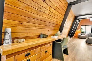 Un interior moderno con un panel de madera, una barra de madera, una silla y un sofá.