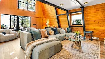 A spacious living area with a large sofa, a coffee table, and a fireplace.