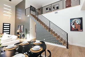 A modern interior with a dining area, staircase, and artwork. - A Desert Dream Perfect Getaway in Old Town (Scottsdale)