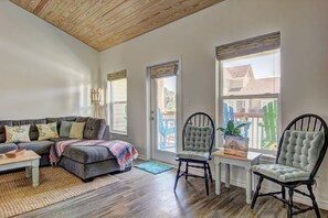 A living room with a sofa, chairs, a coffee table, and a view of the outside. - Borracho Beach- Waterslide Pet Friendly (Port Aransas)