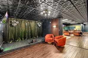 A room with a patterned ceiling, a green curtain, a disco ball, and a vintage orange armchair. - 7k Sqft Estate - Epic Amenities Fun - Sleeps 20 (Asheville)