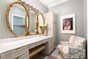 A room with a vanity, a mirror, a dresser, a chair, and a framed picture on the wall. - 7k Sqft Estate - Epic Amenities Fun - Sleeps 20 (Asheville)