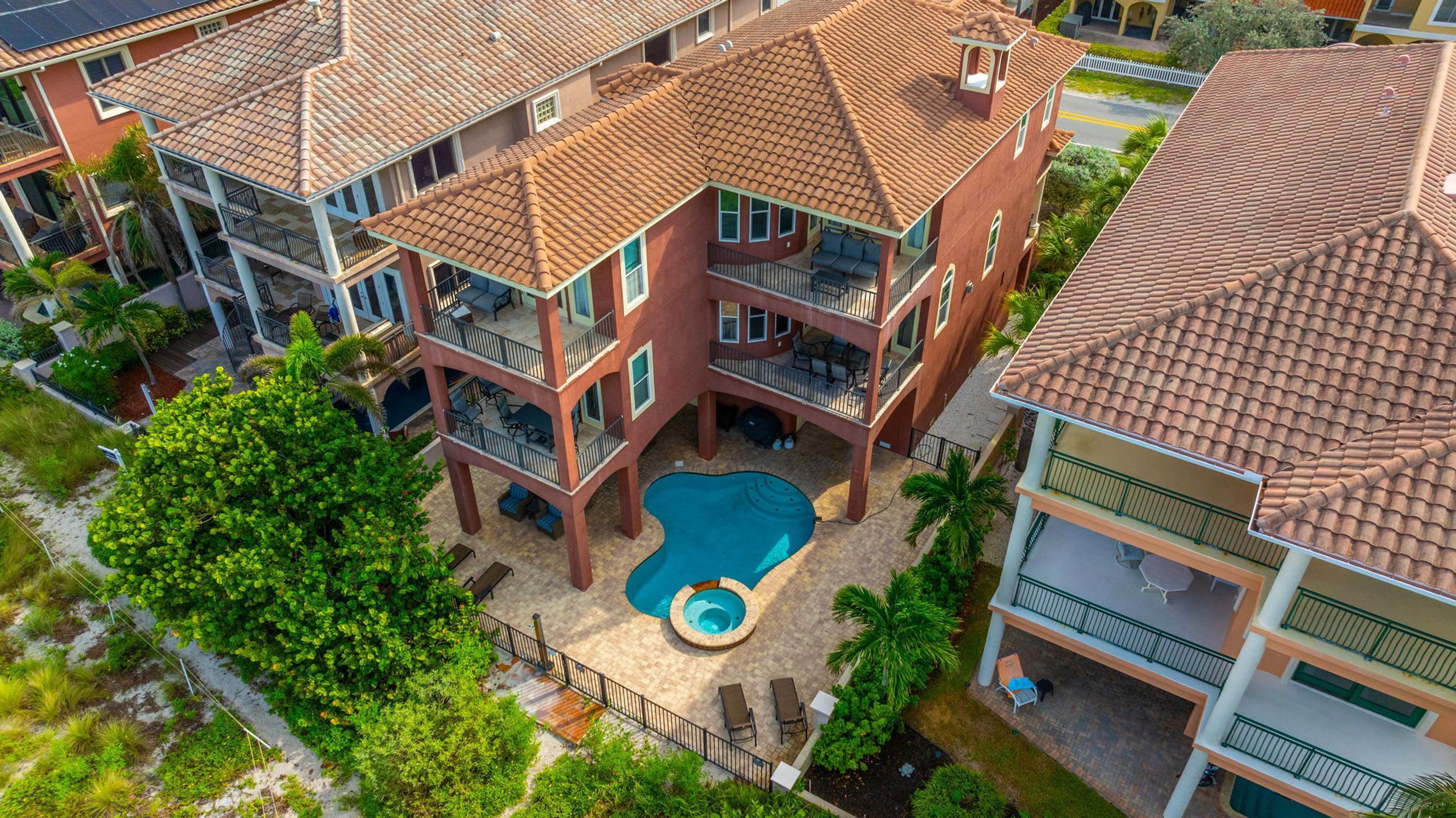 Un edificio de varios pisos con piscina, balcones y zonas de estar al aire libre.