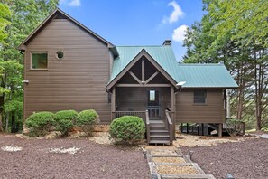 A two-story building with a brown exterior and a green roof. - Mountain Views Games Hot Tub Fire Pit BBQ (Morganton)
