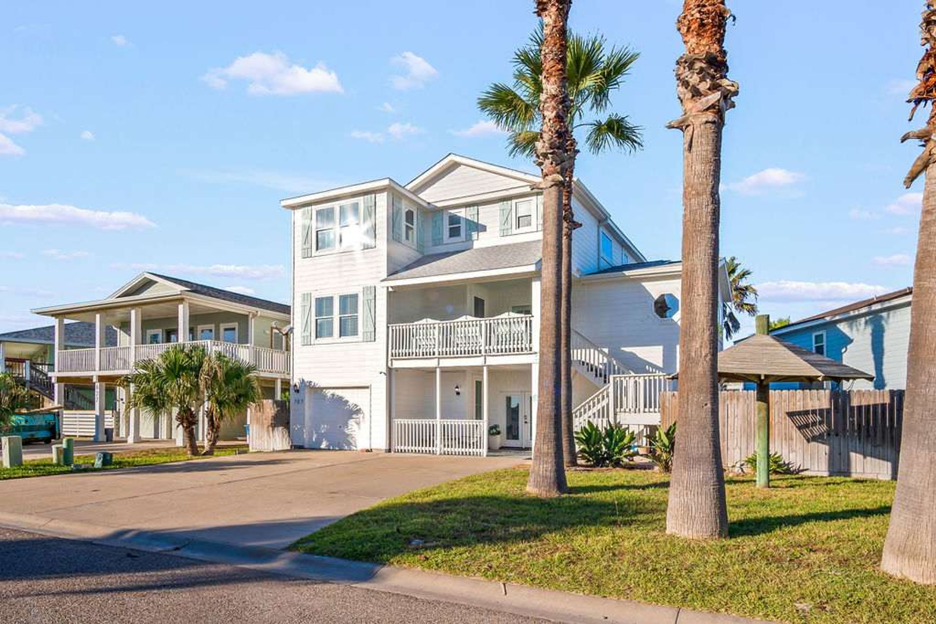 A two-story residential building with a balcony and a covered porch.