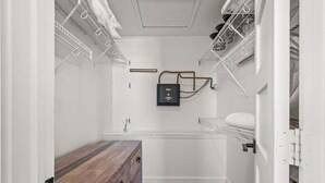 Ein kleines Badezimmer mit einer Holzbank, einem Handtuchhalter und einem kleinen Schrank.