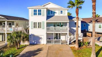 A two-story residential building with a front porch, a balcony, and a garage.