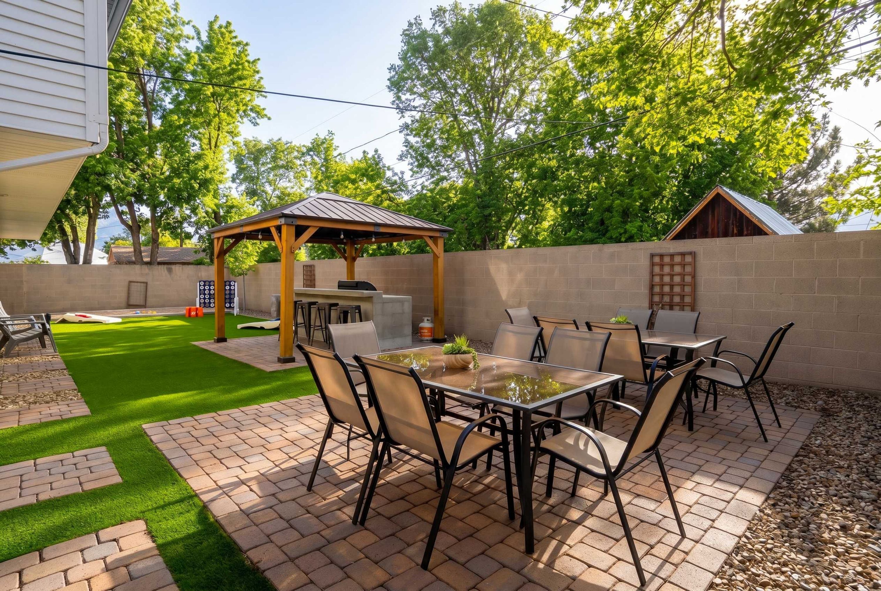 Un espace patio comprenant un barbecue, des sièges d’extérieur et une pergola.