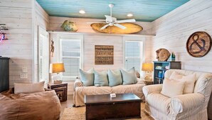 A cozy living room with a ceiling fan, a sofa set, and a coffee table. - Sea Gypsy Fire Pit Community Pool Corn Hole (Port Aransas)