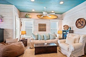 A cozy living room with a ceiling fan, a sofa set, and a coffee table. - Sea Gypsy Fire Pit Community Pool Corn Hole (Port Aransas)