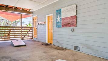 A room with a concrete floor, a wooden door, and a wall with a Texas flag mural.