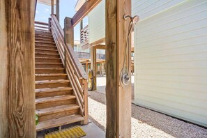 A wooden staircase leading to an upper level, a door with a handle, and a view of the outside. - Sea Gypsy Fire Pit Community Pool Corn Hole (Port Aransas)