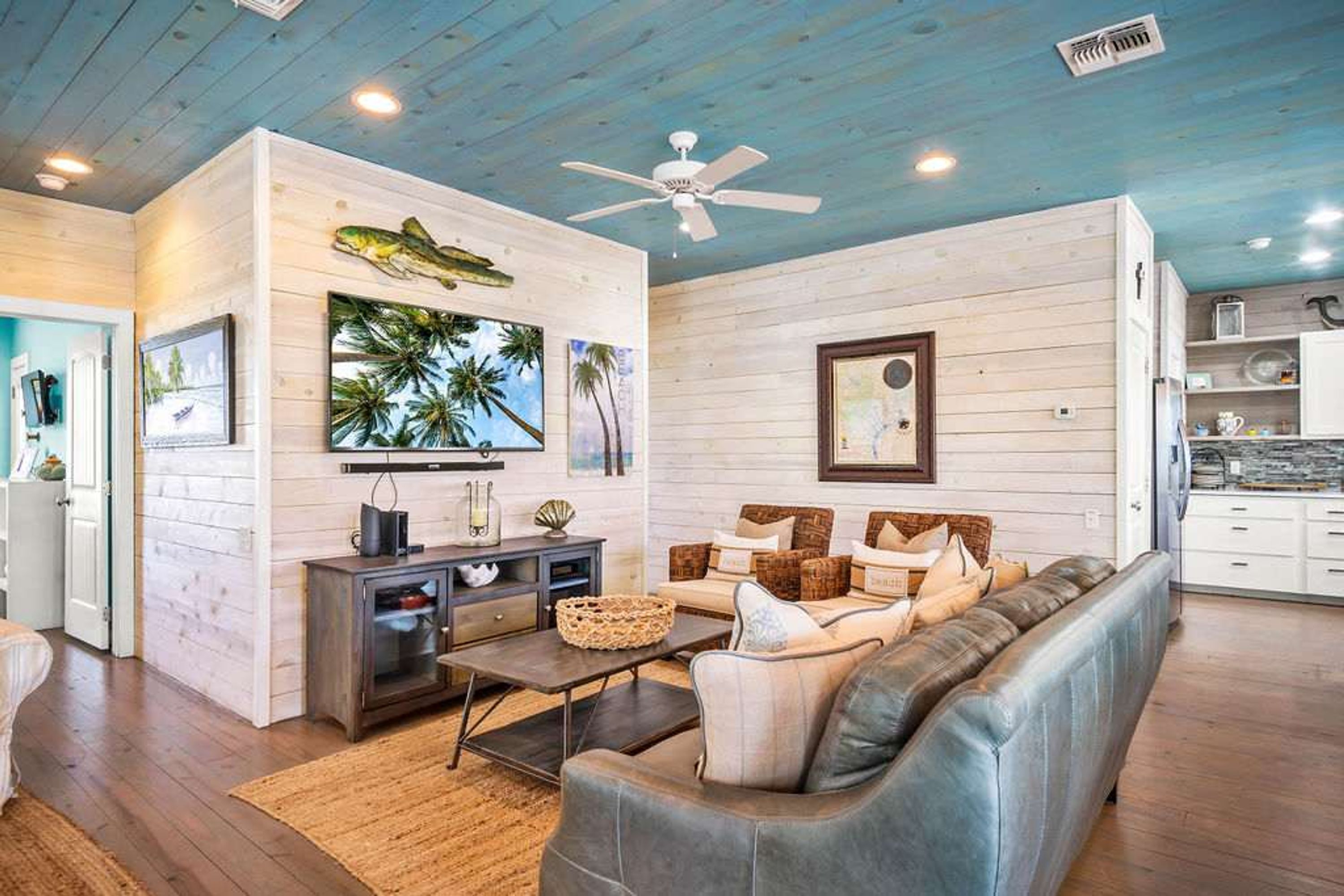 A living room with a sofa, coffee table, and artwork on the wall.