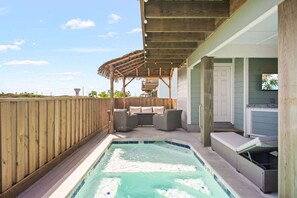 Um quintal com hidromassagem, área de estar externa e um alpendre coberto.
