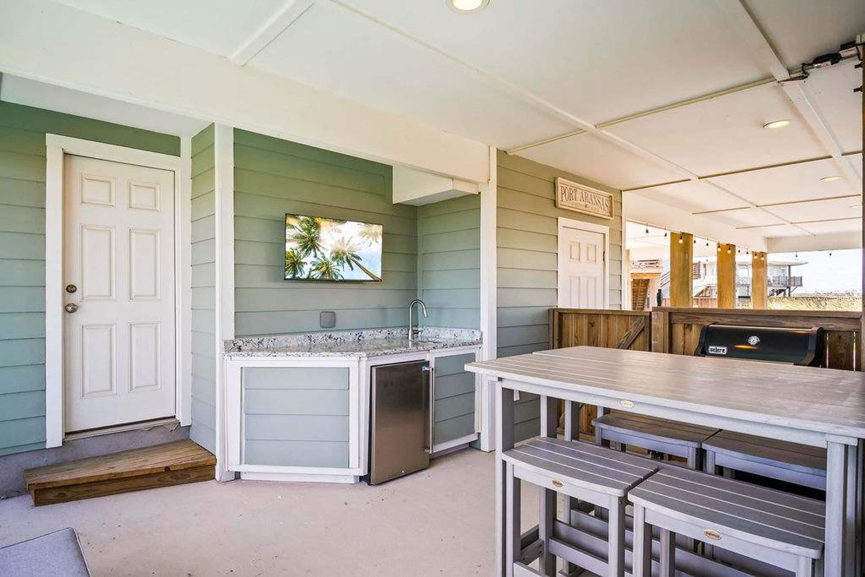 A kitchen area with a countertop, sink, and a refrigerator.