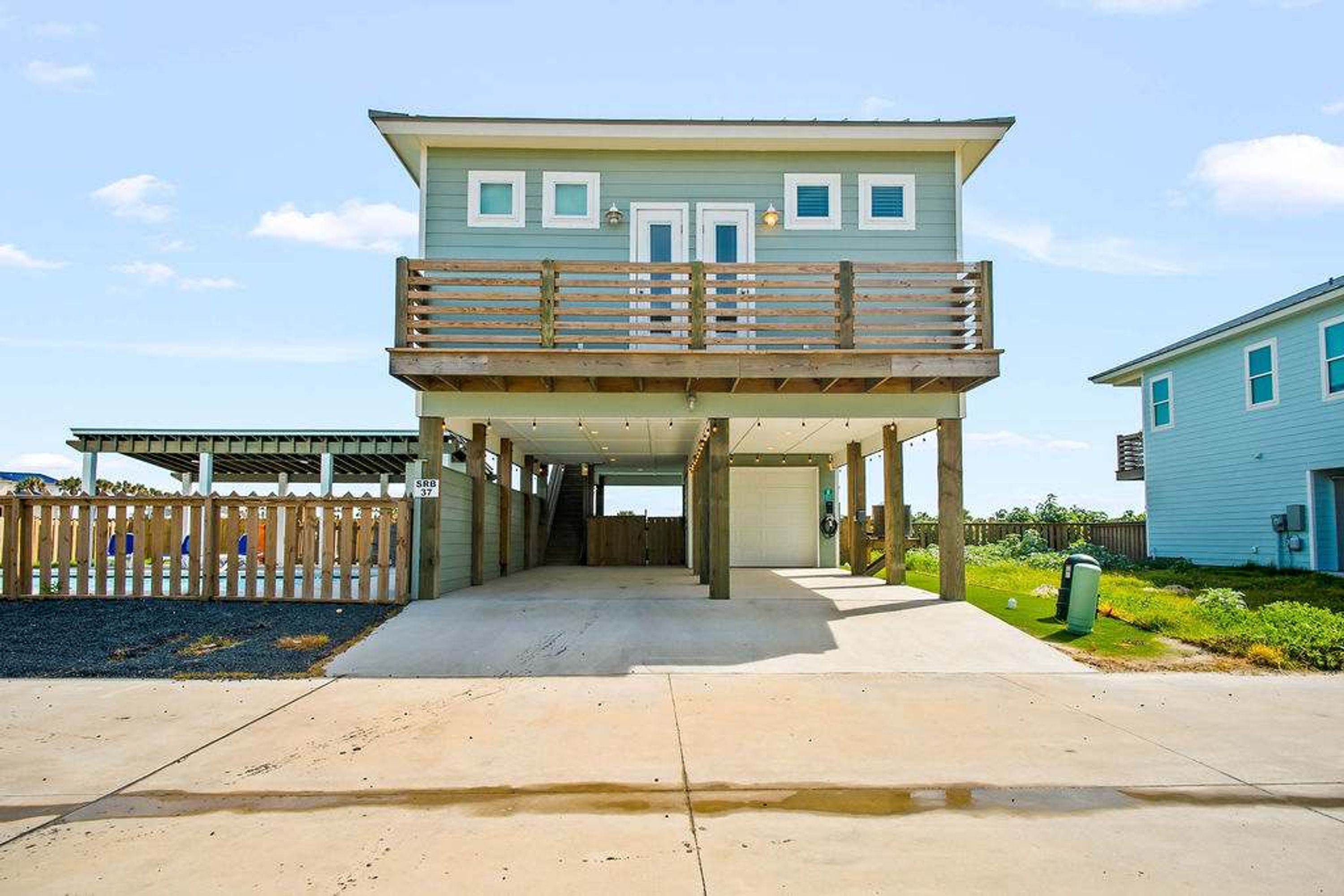 A two-story house with a covered walkway leading to the entrance.