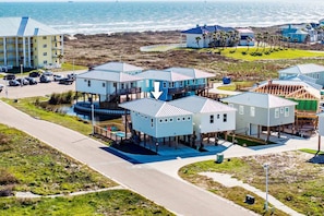 Uma área residencial à beira-mar, com várias casas, um estacionamento e vista para o oceano.