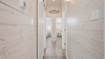 A hallway with wooden walls and a ceiling light fixture.