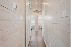 A hallway with wooden walls and a ceiling light fixture. - Save The Ales Boardwalk Private Pool Sleeps 10 (Port Aransas)
