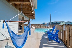 A pool area with a hammock, blue chairs, and a wooden fence. - Save The Ales Boardwalk Private Pool Sleeps 10 (Port Aransas)