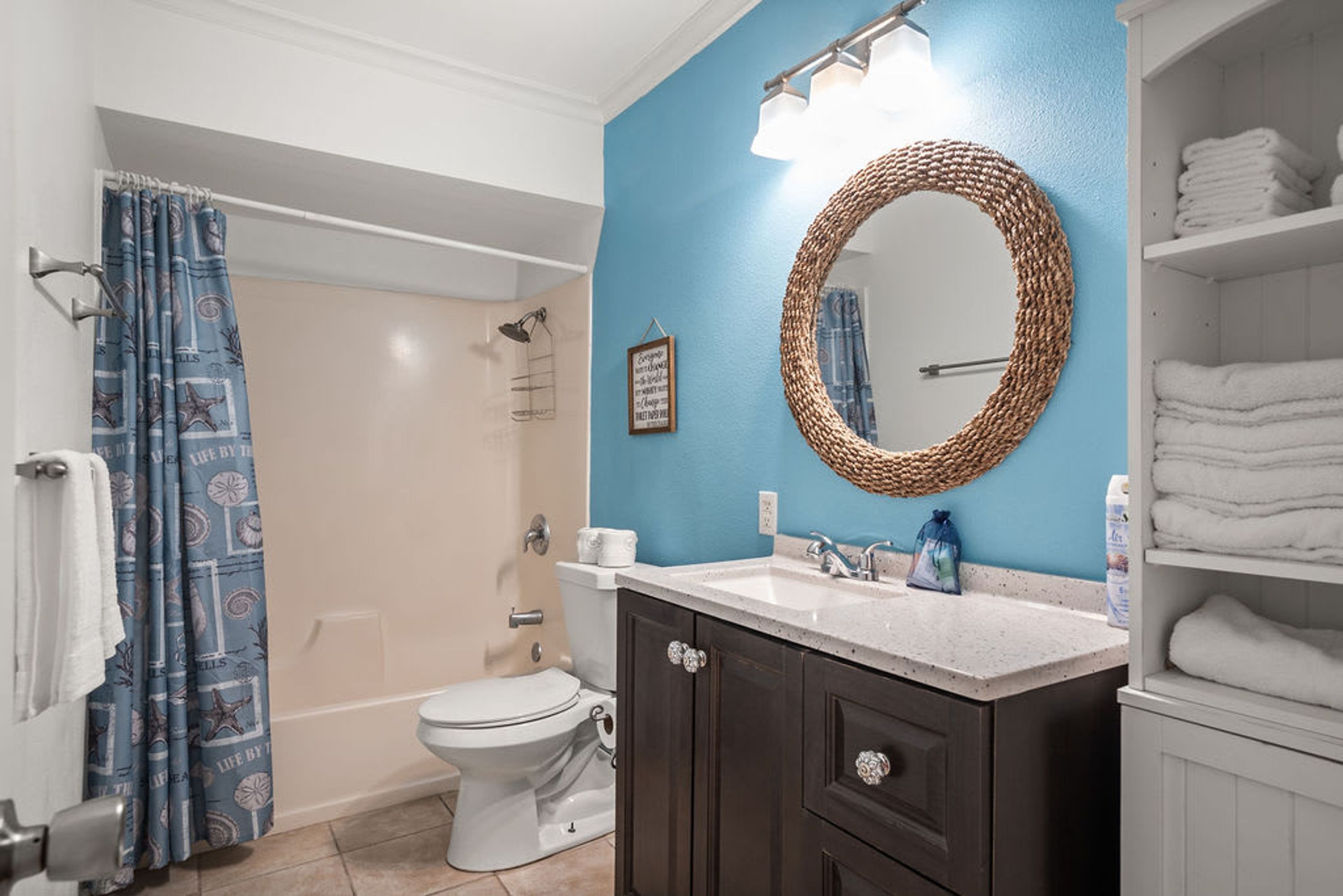 A bathroom with a white toilet, a sink with a mirror, and a shower area.