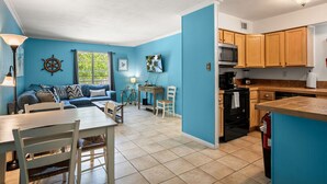 Un espacio habitable compacto con comedor, cocina y vistas al exterior.