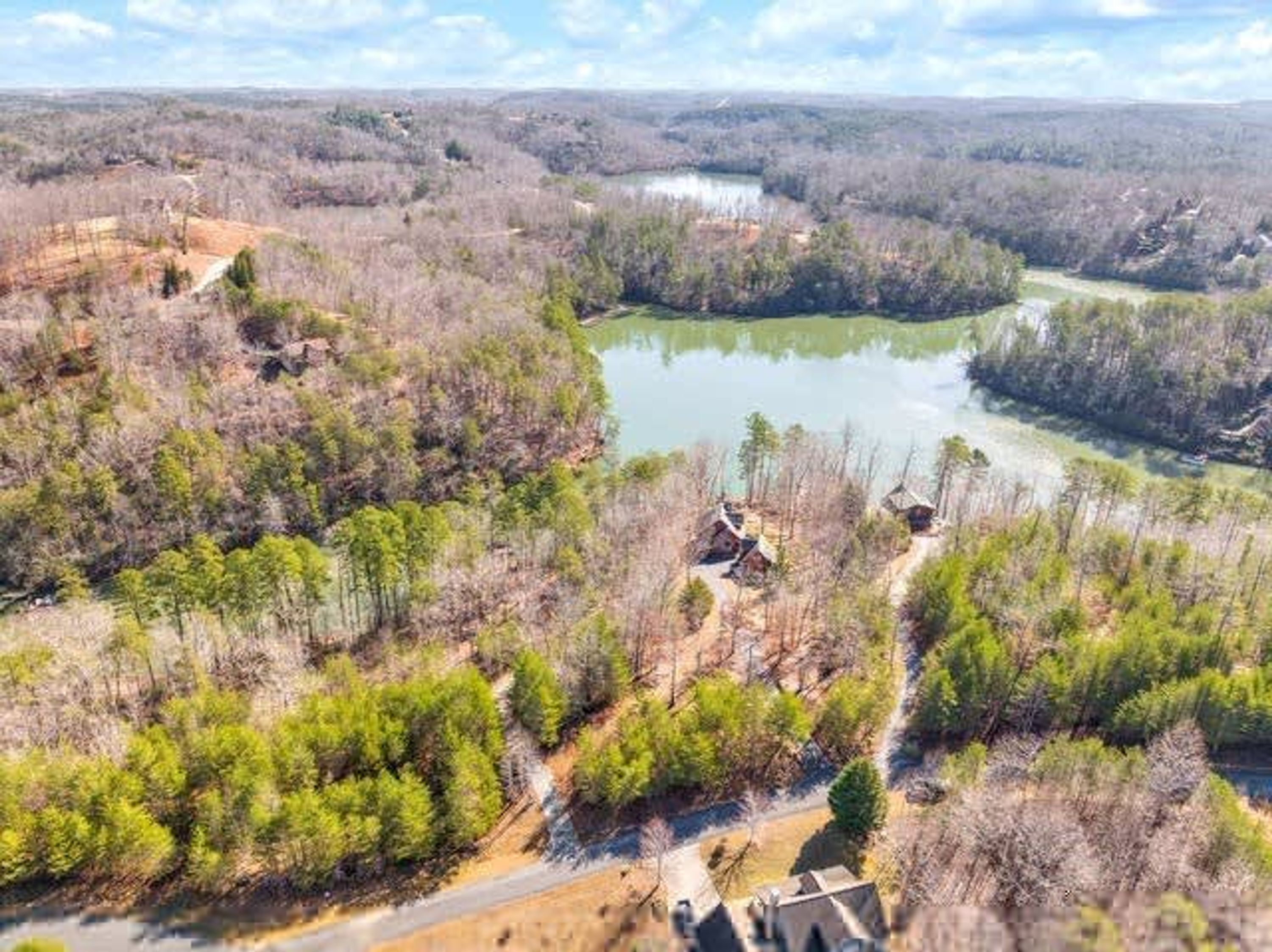 Um rio rodeado por áreas florestais, com cabanas.