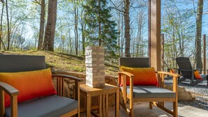Una terraza de madera con dos sillas acolchadas y una pila de bloques de Jenga.