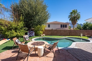 A backyard with a swimming pool, outdoor furniture, and a house in the background. - Family Fun Sleeps 12 Pool Fire Pit Puttputt (Oro Valley)