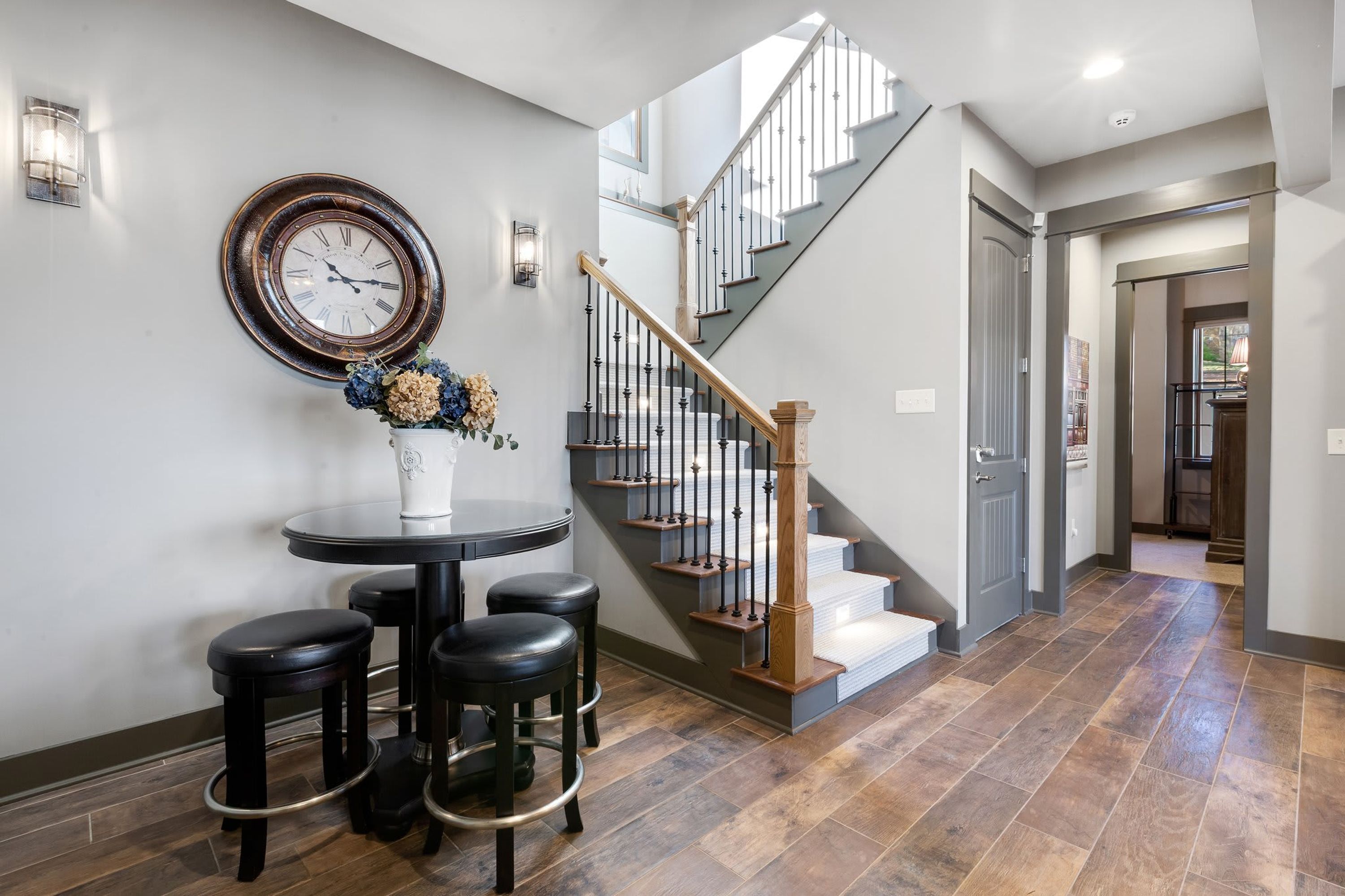 A staircase with a wooden handrail and metal balusters, leading to a landing with a white door.