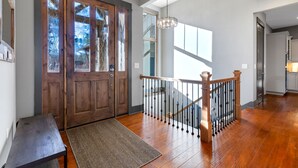 A wooden staircase with a metal railing, a wooden bench, and a rug leading to a door with frosted glass panels. - Lakefront Getaway Dock Fire Pit Kayak Games (Seneca)