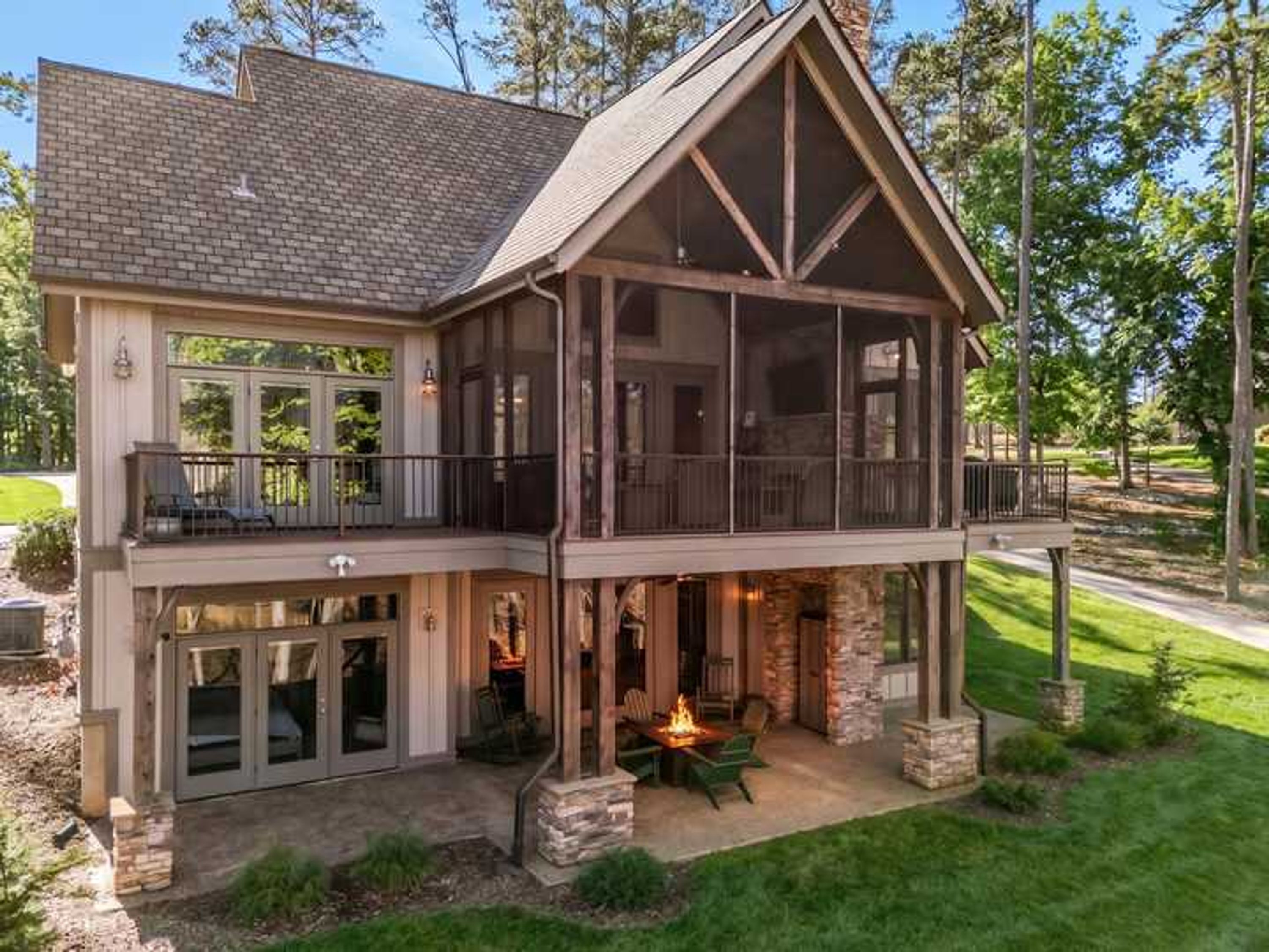 A two-story house with a balcony, a fireplace, and a stone foundation.