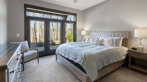 A bedroom with a large bed, two bedside tables with lamps, a ceiling fan, and a view of trees through the door. - Lakefront Getaway Dock Fire Pit Kayak Games (Seneca)