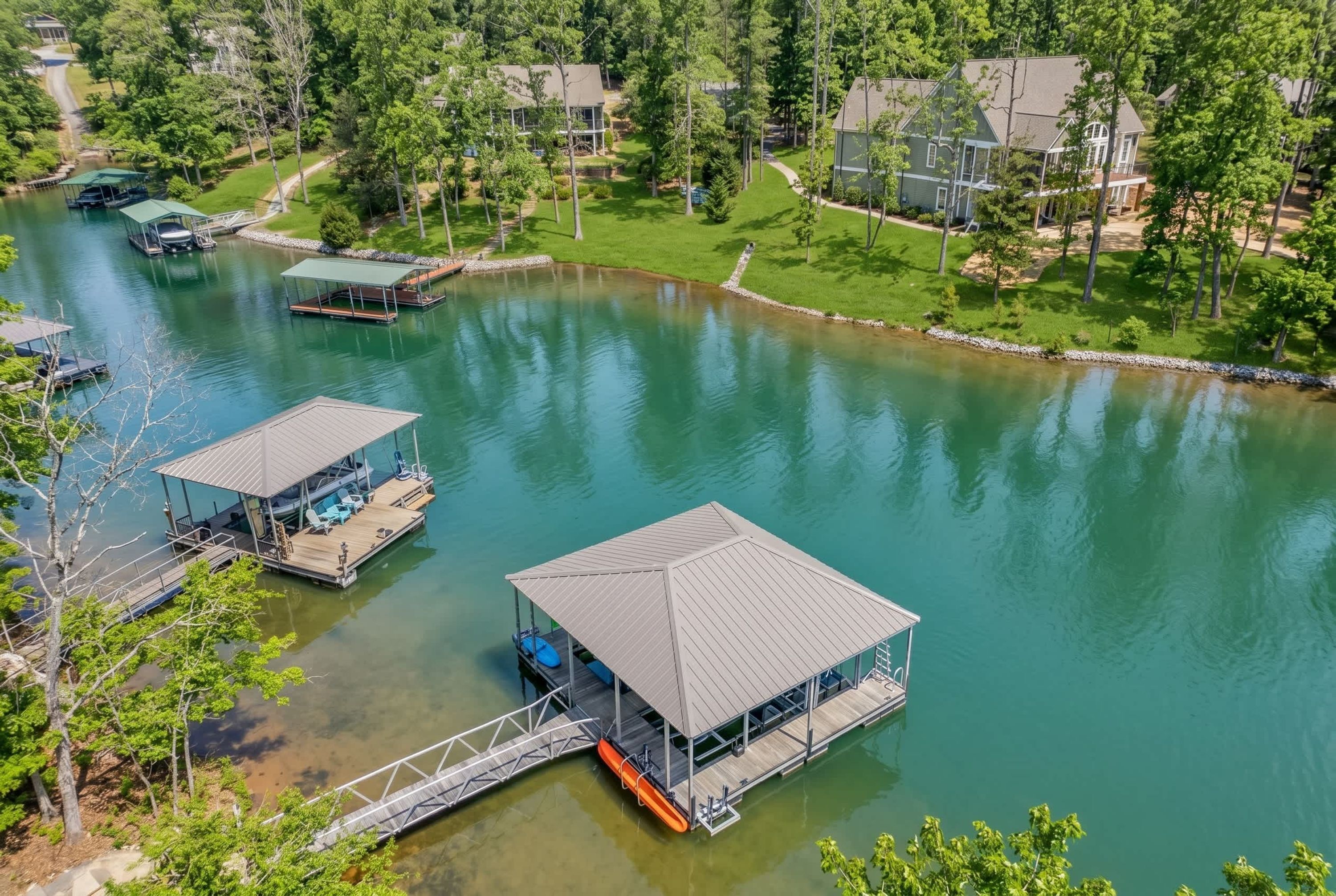 A lakeside property with two docked boats and a covered dock area.