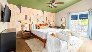 A bedroom with a bed, bedside tables, a TV, a ceiling fan, and a view of the outdoors. - Sport Court Pool Hot Tub Pool Table Fire Pit Games (Glendale)