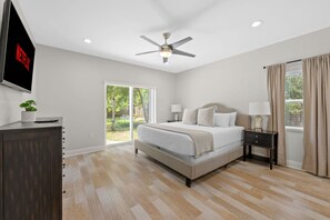 A bedroom with a bed, nightstands, a TV, and a ceiling fan. - Sleeps 8 Private Pool Dog Friendly Balcony (Sarasota)