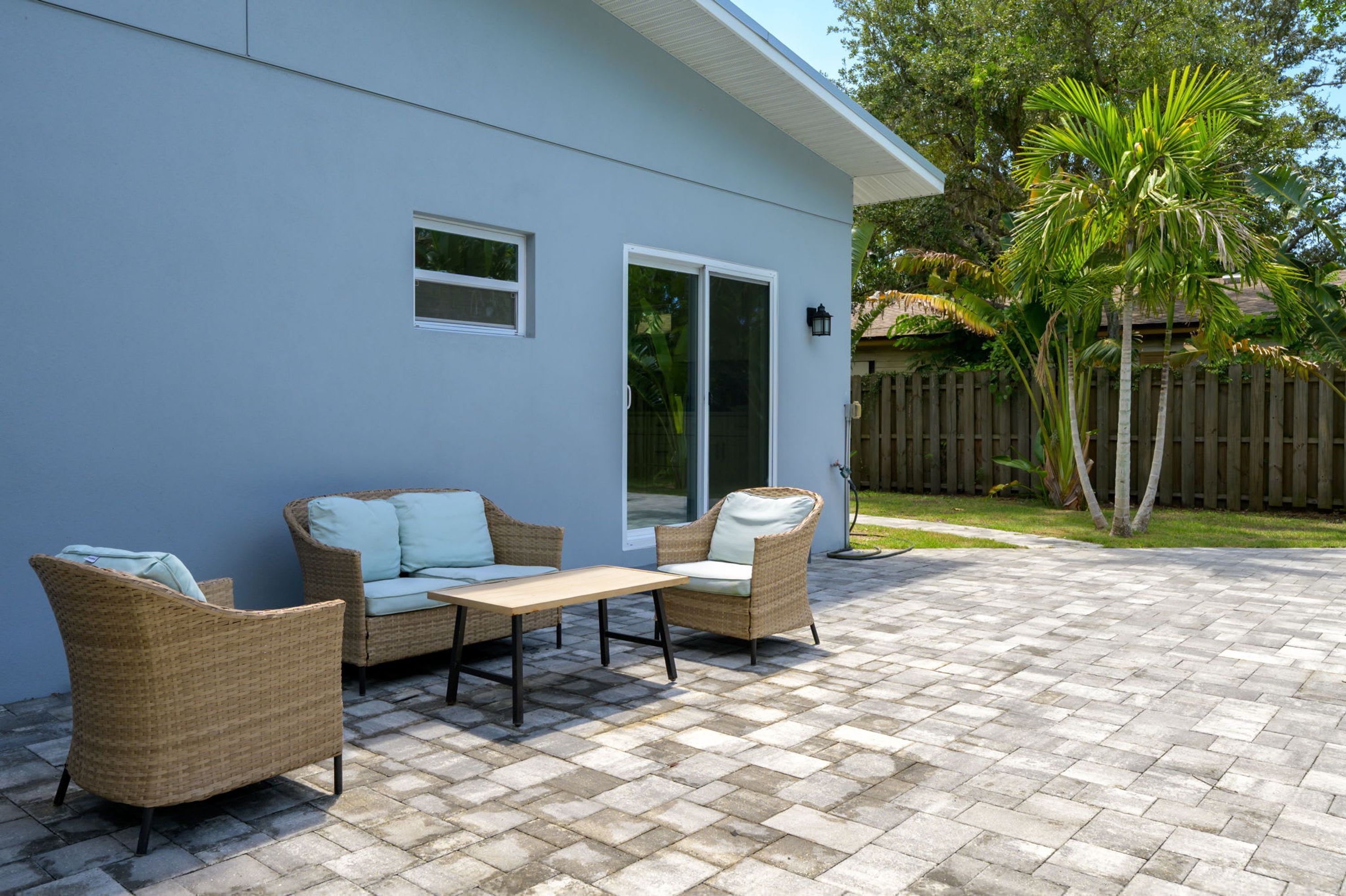 Un patio con mobiliario de mimbre y una mesa.