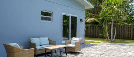 Un patio con mobiliario de mimbre y una mesa.